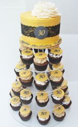 Thirtieth birthday yellow cake with sheer fabric with 4 cupcake levels underneath.JPG