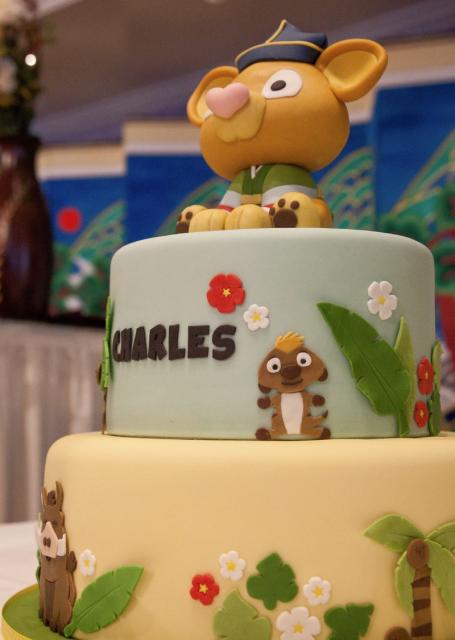 2 tier safari theme cake with baby animal on top.JPG