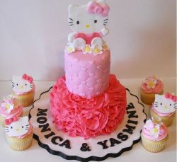 2 tier Hello Kitty pink cake with accompanying cupcakes.JPG