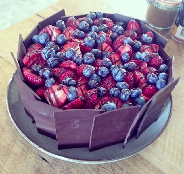 Fresh strawberry and blueberries cake with chocolate drizzle and slabs surrounding.JPG