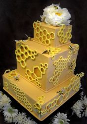 3 tier rectangular yellow cake with honeycomb theme with white flower on top.JPG
