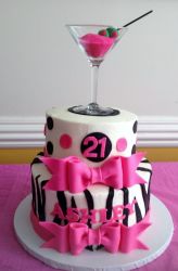Two tier women's 21st birthday cake with zebra stripes pink bows and martini glass on top.JPG