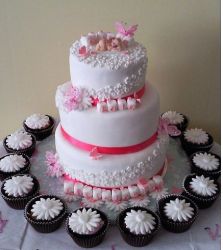 Three tiers girl Christening cakes with small chocolate cupcakes.JPG