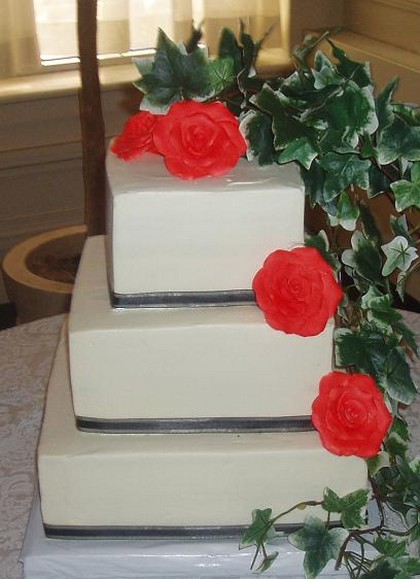 Wedding square cake with bright red flowers