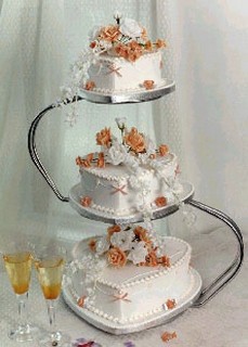wedding cake royal iced with orange flowers and heart shape cake in three tier