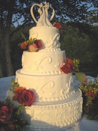 wedding cake with traditional patterns with colorful flowers and princess topper