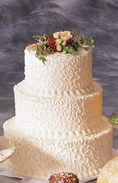 class and elegant wedding cake with beautiful patterns and fresh flowers topper