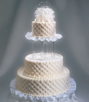 picture of wedding cakes in three tier in creamy color with cool patterns with floral topper