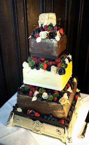 Three tier square wedding cake with drama masks as toppers.JPG