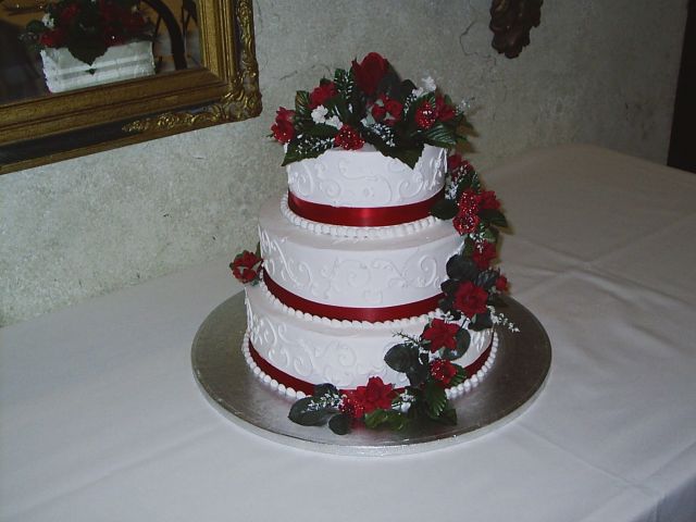 Three tier whtie Wedding Cakes with red roses and red ribbons