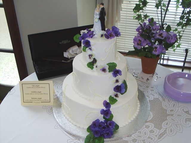 Photo of beautiful Wedding Cakes in white with dark purple flowers