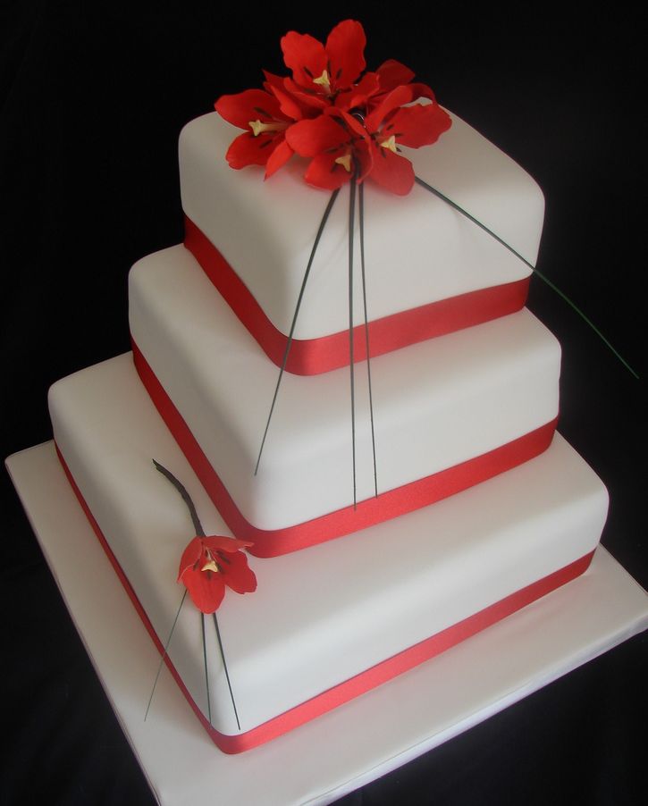 White three-tier wedding cake with red tulips.JPG