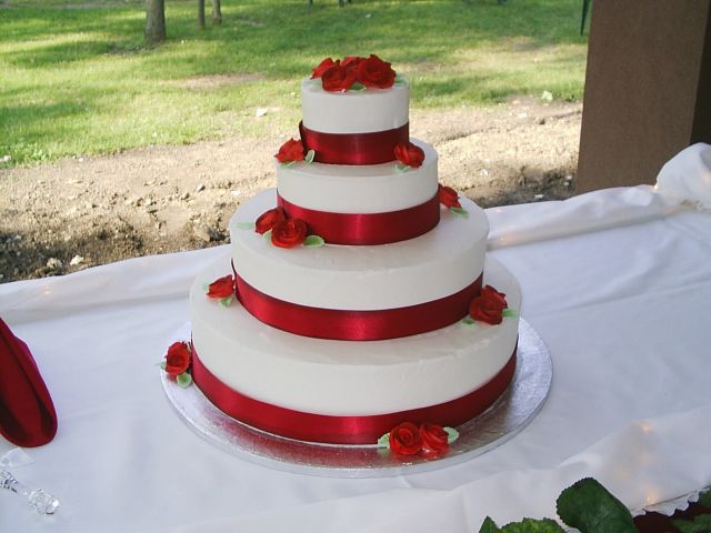 Four tier Wedding Cakes with red ribbons and red flowers