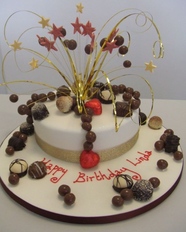 Round white birthday cake with chocolate treats.JPG