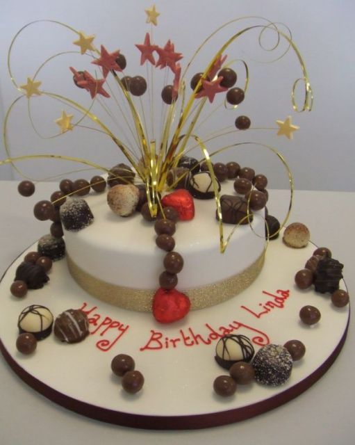 Round white birthday cake with chocolate treats.JPG