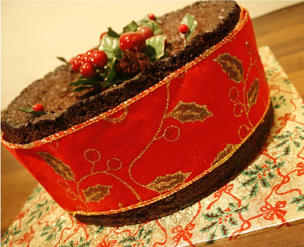 Chocolate Christmas cake with gian red ribbbon wrapped around.JPG
