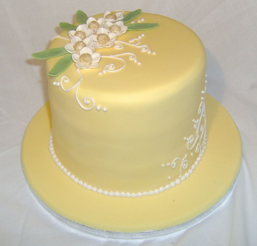 Elegant yellow birthday cake with white pearl beads and flowers.JPG