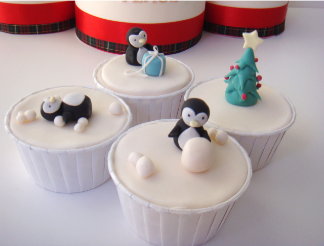 Christmas cupcakes with pingwins playing with snow balls and gifts.PNG
