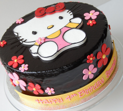 Japanese Hello Kitty cake with Hello kitty shape cake decor and small flowers.PNG