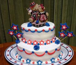 Two tiers 4th of July cake with bears cake toppers holding US flags.JPG