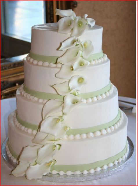White butter cream wedding cake with fondant ribbon and flower petals.jpg