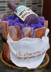 Wine bottle inside a wooden grape basket birthday cake with message that says Like a fine wine, you get better with age.JPG