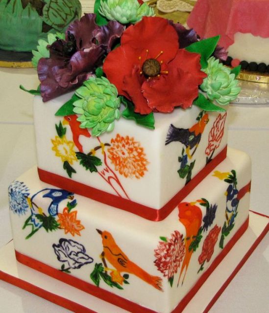 Two tier white cake with various birds and flower toppers.JPG
