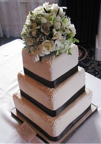 3 Tier white wedding cake with flower bouquet on top.JPG