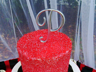 Red sugar coated wedding cake with cake topper monogram.PNG