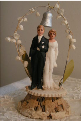 Traditional wedding cake toppers with flowered arch with silver bell.PNG