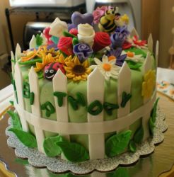 Garden theme birthday cake with white picket fence and ladyug and bee.JPG