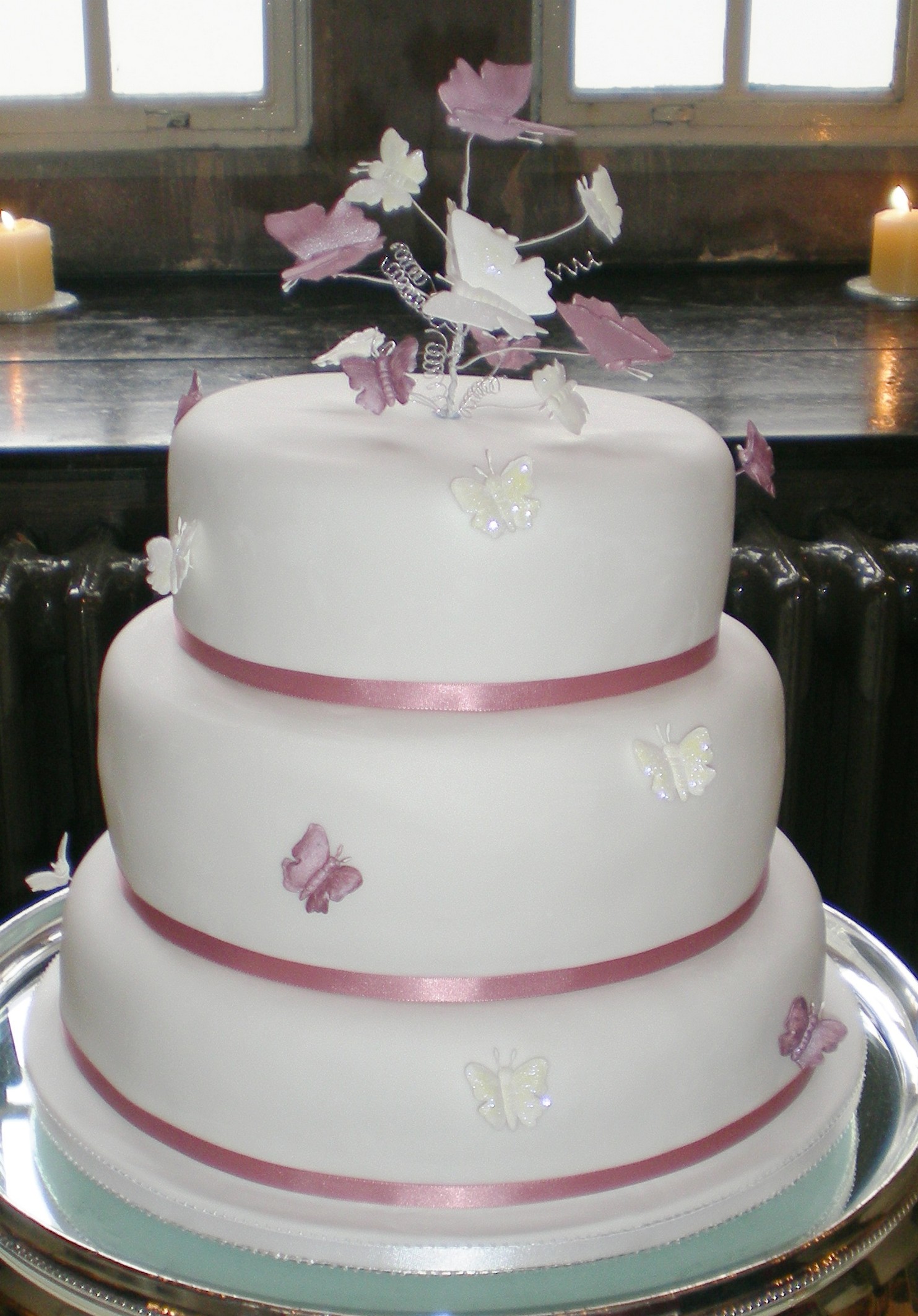 picture of big and round wedding cake with ribons in pink