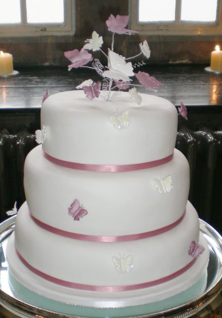 picture of big and round wedding cake with ribons in pink