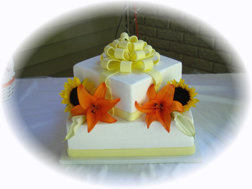 wedding cake in a gift box shape with lilies and sun flowers picture