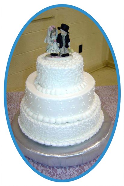 classic white wedding cake with wedding top with bride and groom