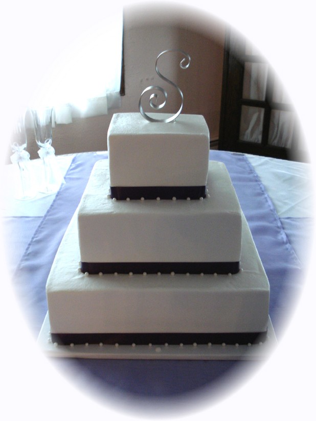 big white sqaure wedding cake with green ribbons picture