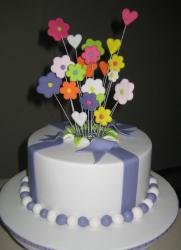 Round white cake with fondant flowers popping out of the middle.JPG