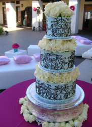 Chic blue wedding cake with chocolate patterns with white roses cake topper.PNG
