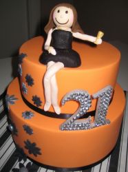 Two tier orange cake with woman in black dress for 21st birthday.JPG