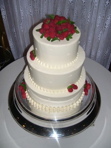 traditional white wedding cake with red flowers