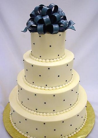 four tier wedding cake with dark blue topper