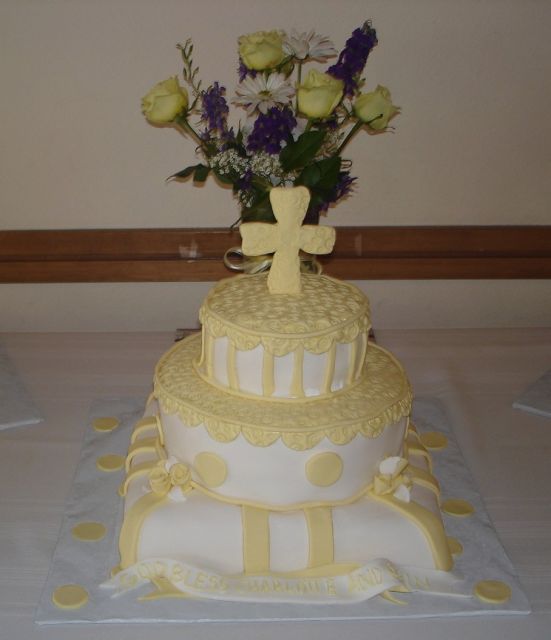 Christain wedding cake with cross in yellow color with roses