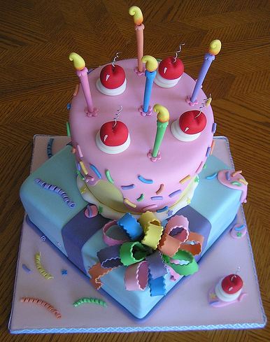 Two tier cake with faux candles and giftbox tier on the bottom.JPG