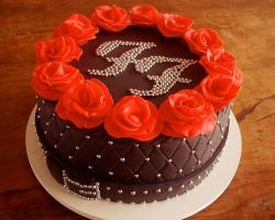 Round elegant chocolate cake with monogram and red roses on top.JPG