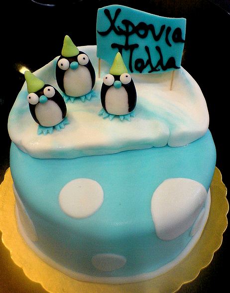 Three penguins on ice atop of blue round cake.JPG