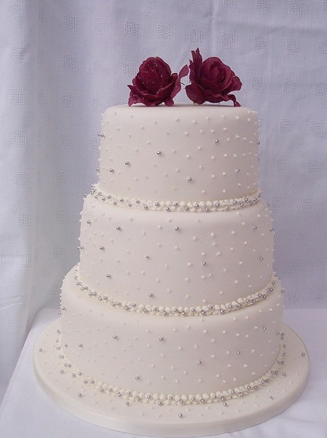 pretty wedding cake with dark roses on top