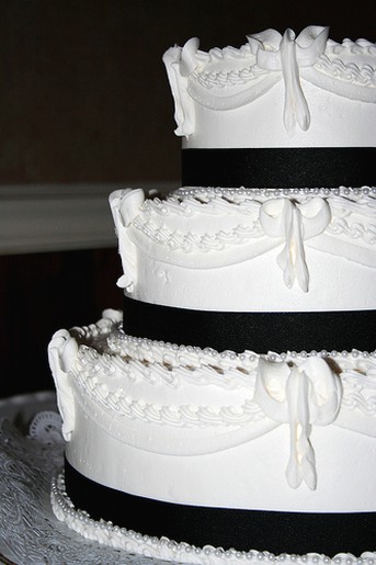 white wedding cake with black ribbons