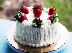 Small white cream cake with fresh strawberries on top.JPG