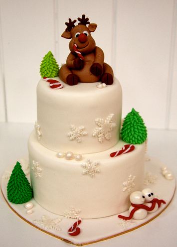 Two tier round white Christmas cake with reindeer on top.JPG