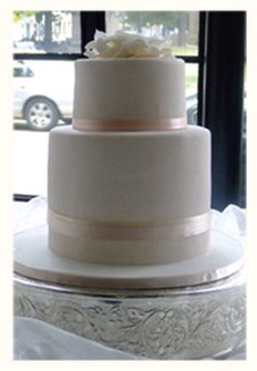 trendy wedding cake with peach ribbon with elegant topper